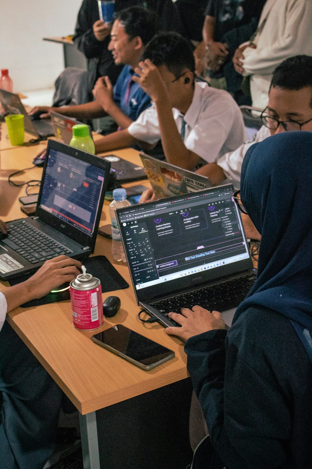 students-working-on-laptops-at-a-shared-desk-rh4xapy-hai